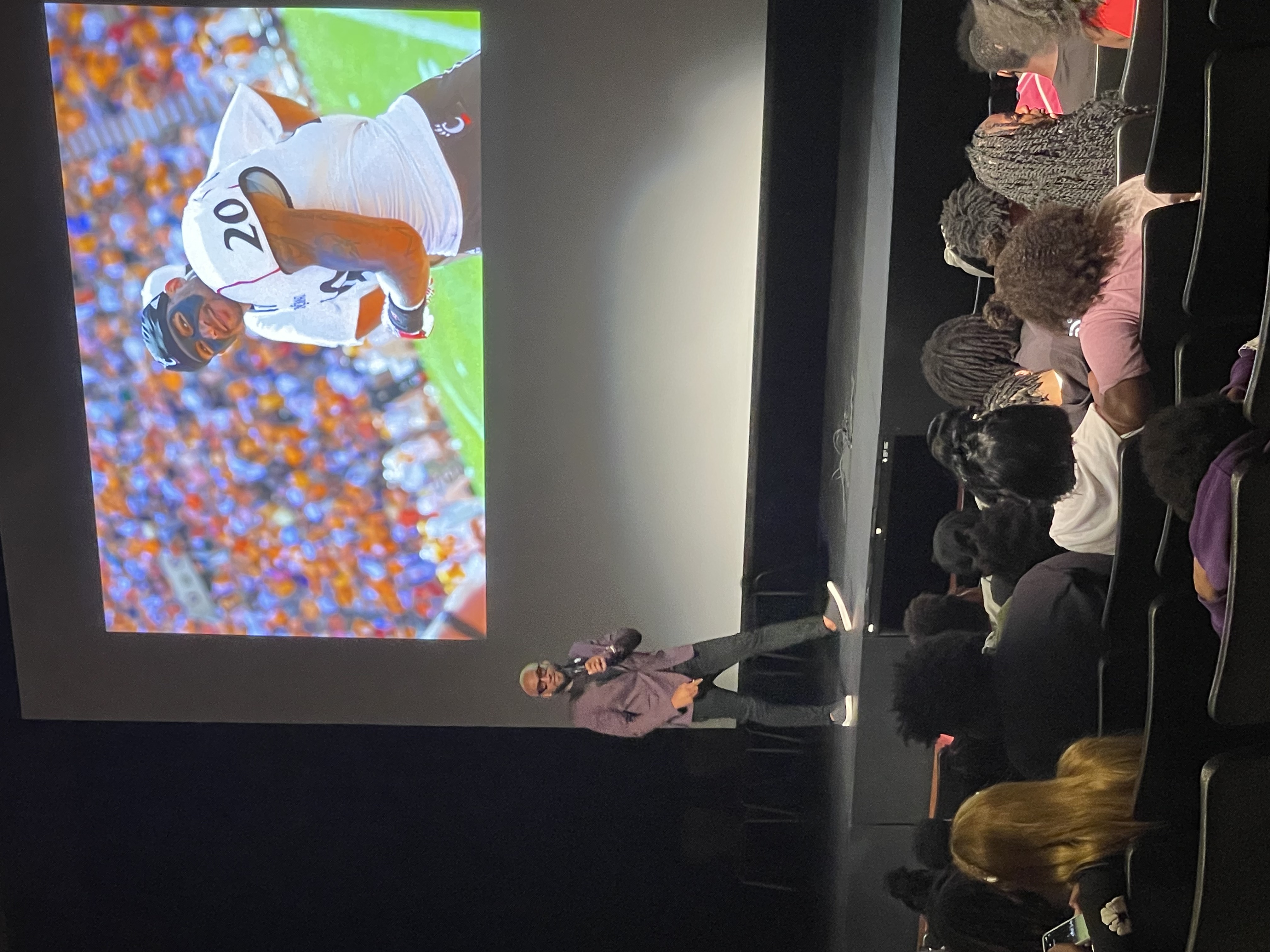 Chris on stage with football projection